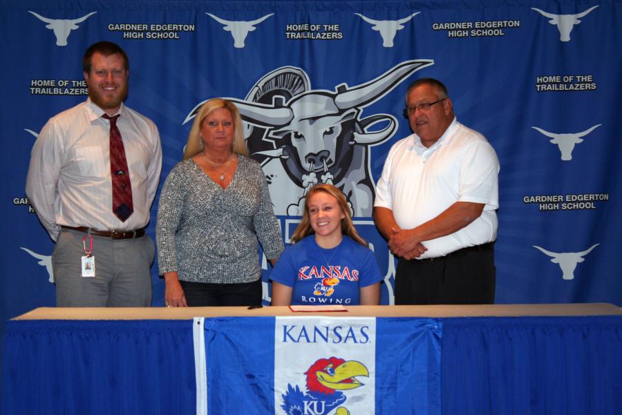 Marissa Gray poses with her track coach John Yockey and her family after signing to the University of Kansas Rowing Team.