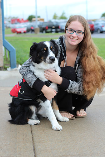 Junior Cassidy Weidler poses with her service dog, Picasso. Picasso alerts Weidler when her blood sugar drops.
