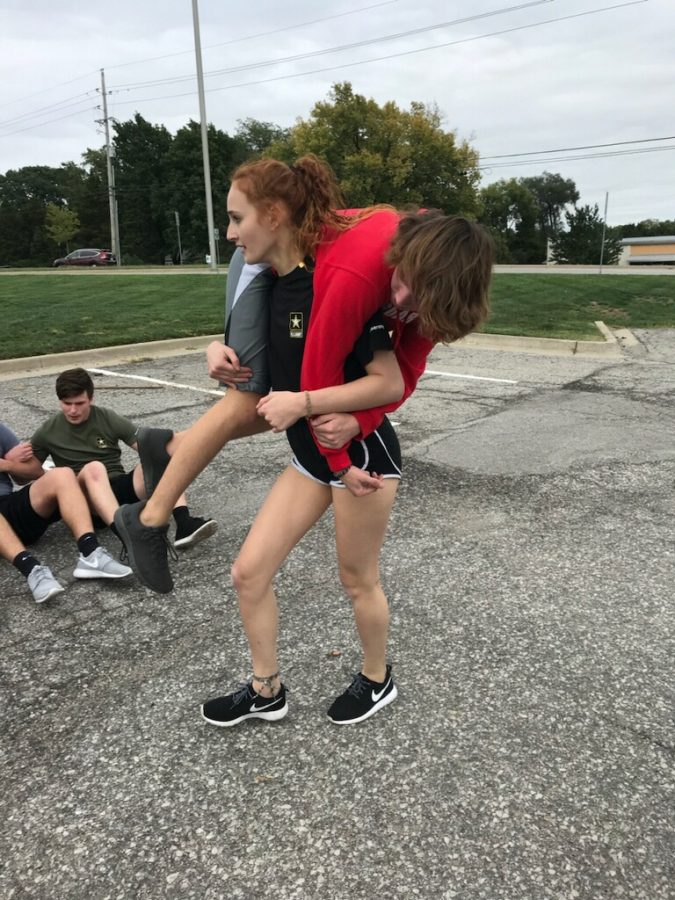 A delayed entry program recruit carries another recruit during a PT session. Photo Courtesy of: SSG Courtney Hess 