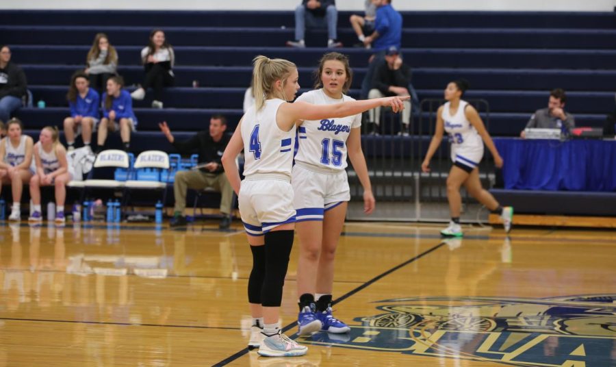 Senior Kaelin Platt and sophomore Rhiannon Folsom discussing where to move next on offense as the other team shoots a free throw.