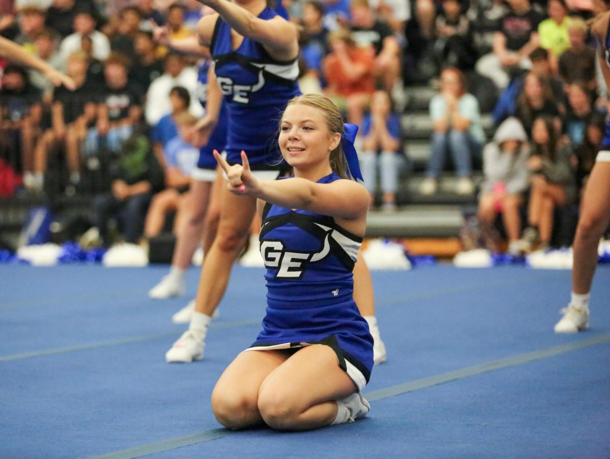 Junior Bridgett Kessler holding up the Blazer sign after finishing a routine.